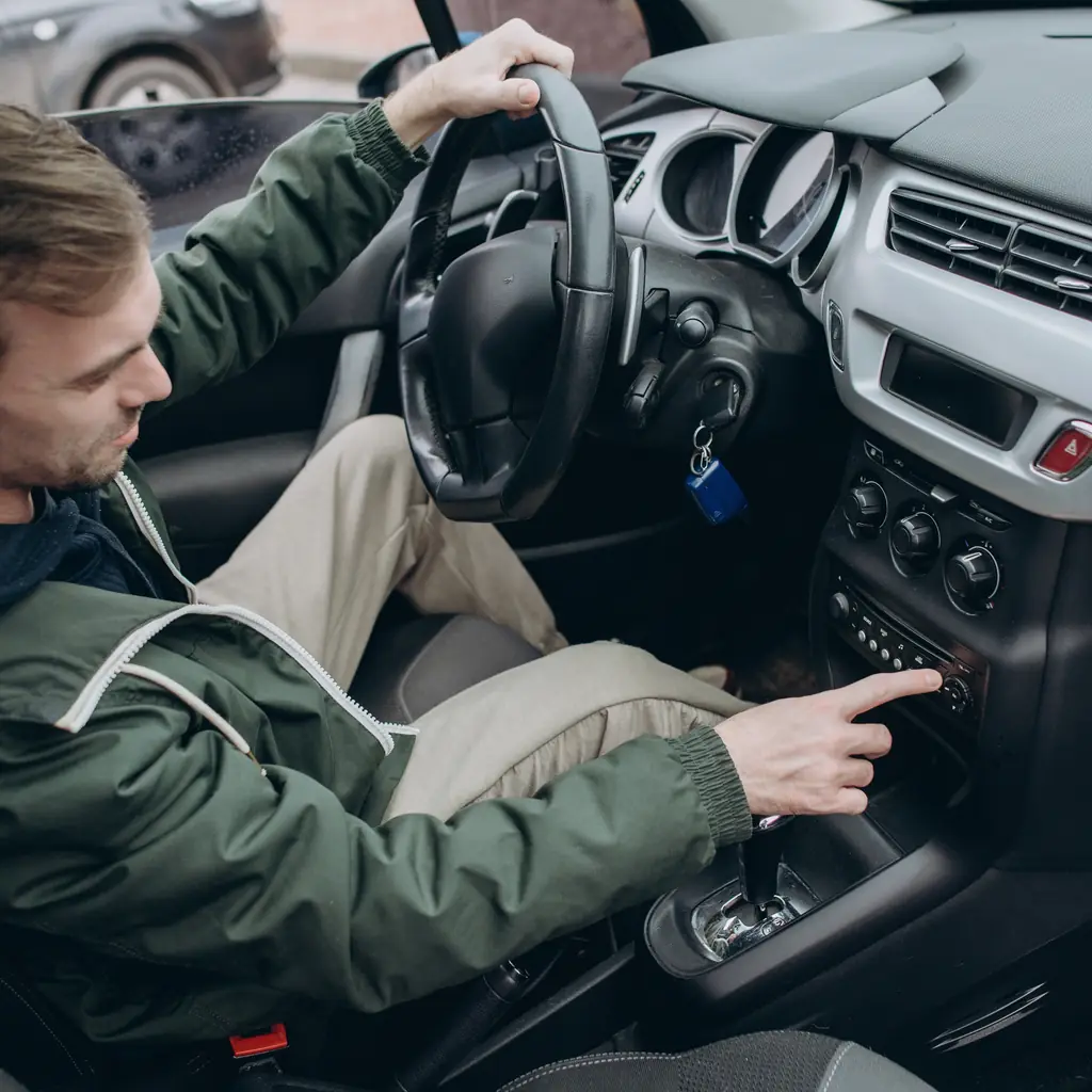 A driver adjusting controls on the center dashboard.