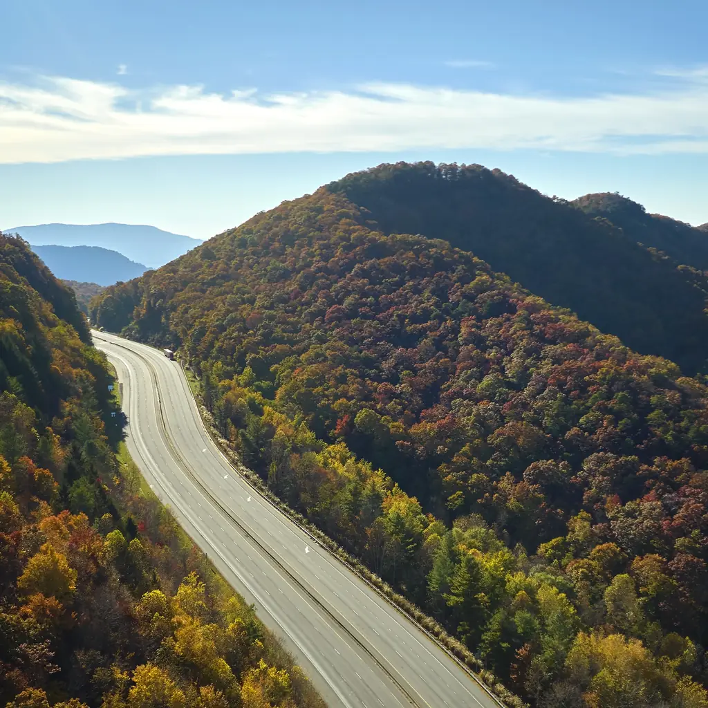 A paved highway winding through a mountainous landscape.