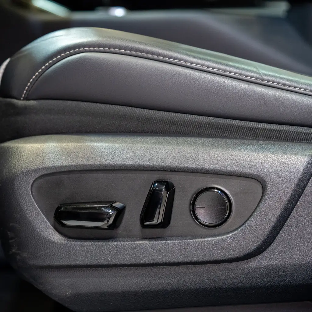 Power-seat adjustment switches on the side of a front seat.