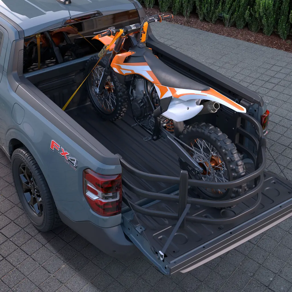 A motorcycle and other cargo secured in a Ford Maverick bed.