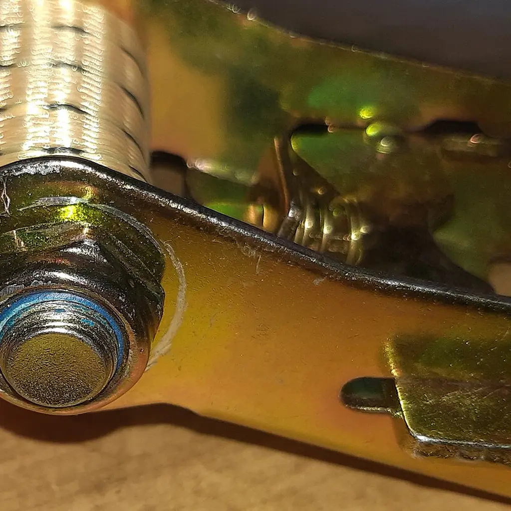 Close-up of the ratchet mechanism of a cargo tie-down strap.