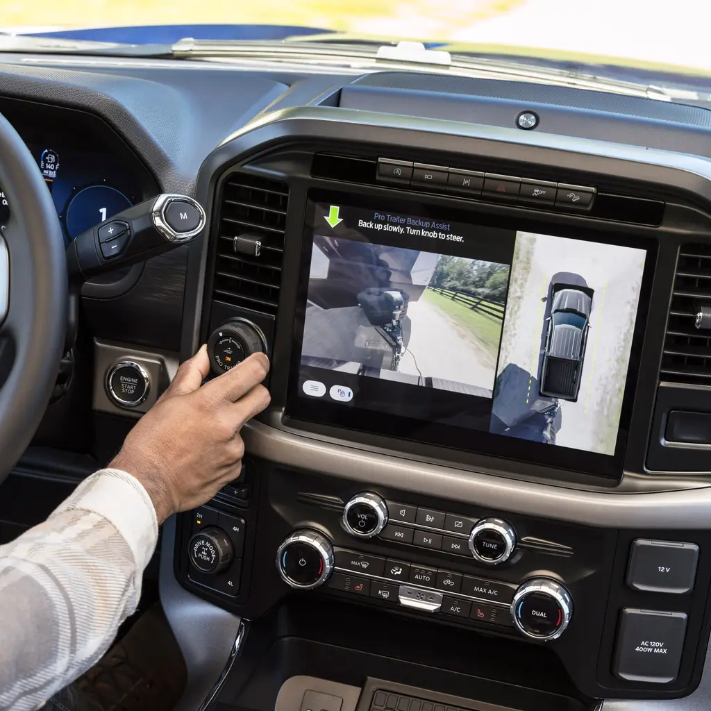 A driver uses the Ford F-150 trailer camera display while parked.
