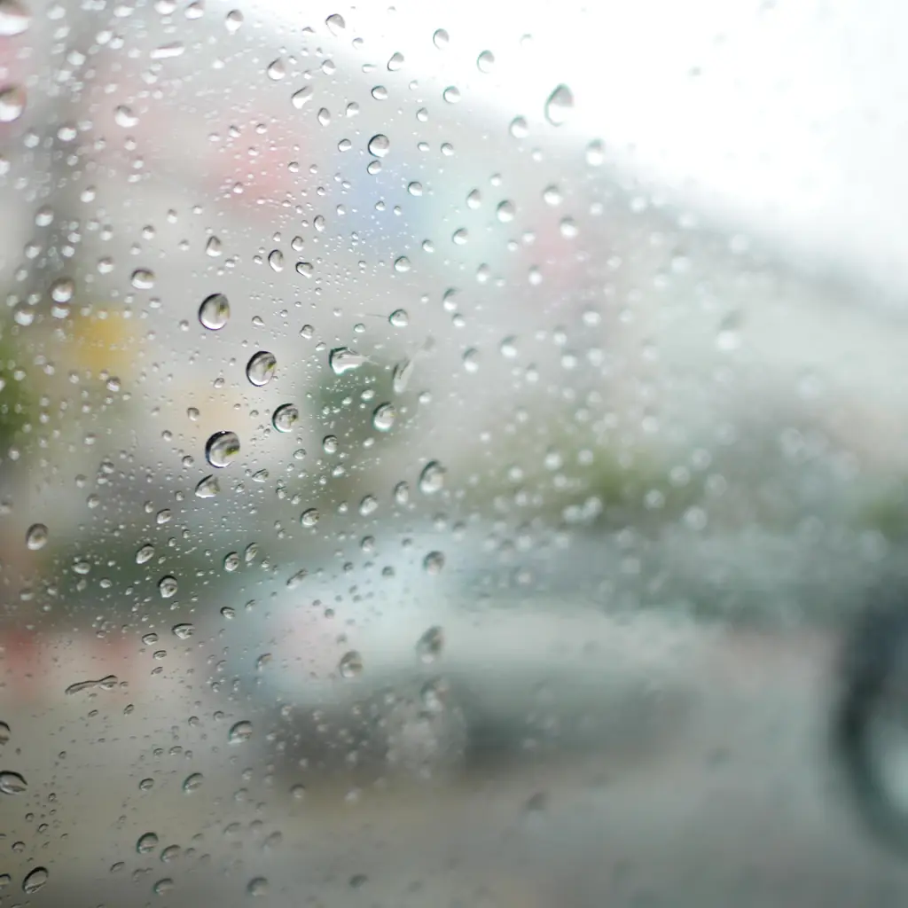 Rain droplets covering a vehicle window.