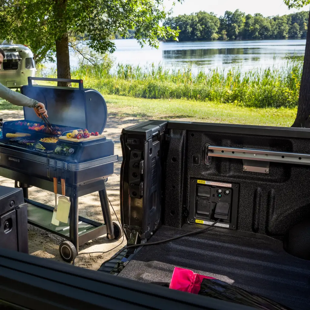 A Ford F-150 powers a grill using its bed-mounted Pro Power Onboard system.