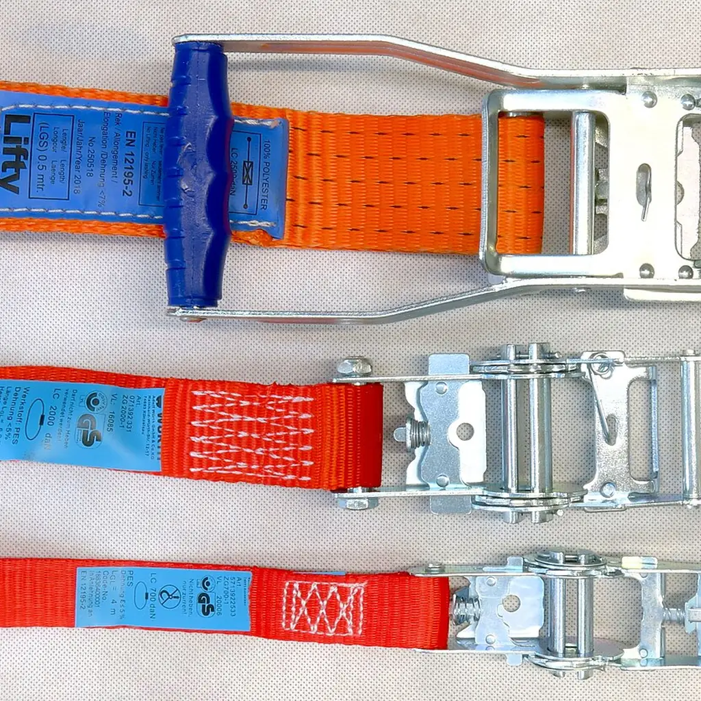 Three cargo ratchet straps with their buckles open.
