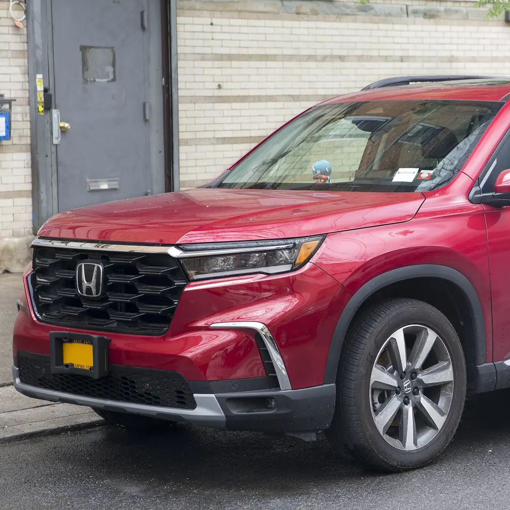 Front quarter of a red fourth-generation Honda Pilot Touring.