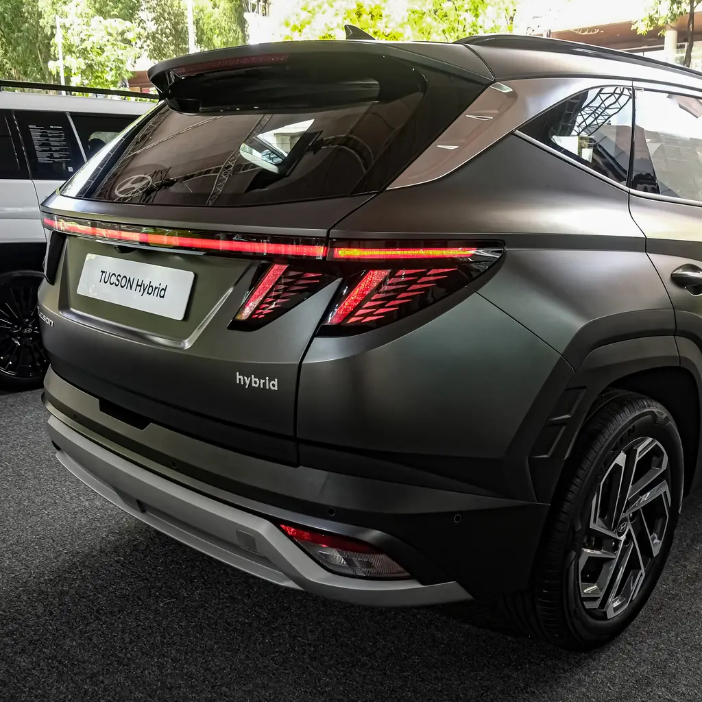 Rear liftgate and taillights of a green facelift Hyundai Tucson Hybrid.